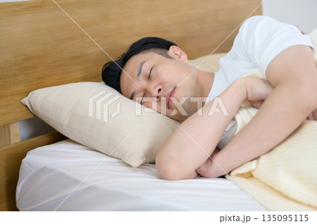 ベッドで横向きに眠る男性 ベッドで横向きに眠る男性 135095115