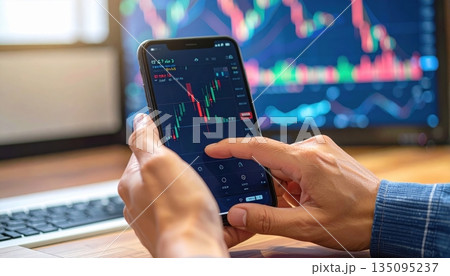 Hand holding a remote control for watching television, with a finger pressing the channel button on the digital keypad 135095237