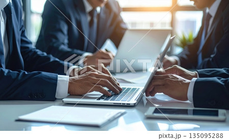 Close-up of a businessman's hands typing on a laptop keyboard in the office, illustrating business communication and technology work Close-up of a businessman's hands typing on a laptop keyboard in the office, illustrating business communication and technology work 135095288