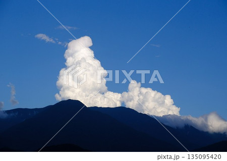 山の稜線の上に発達する入道雲と青空 135095420
