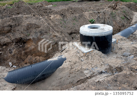 Construction site showing wastewater management system installation in a sandy trench Construction site showing wastewater management system installation in a sandy trench 135095752