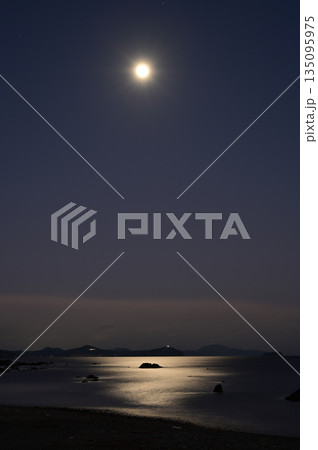 月明かりが海を照らす幻想的な夜の海岸風景、水面に輝くムーンロードと静寂な夜空 月明かりが海を照らす幻想的な夜の海岸風景、水面に輝くムーンロードと静寂な夜空 135095975