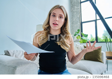 Webcam view young serious woman with business papers having video 135096468