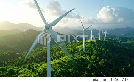Green renewable wind power turbines on a grassy field generating alternative electric energy under a blue sky in the farm landscape 135097372