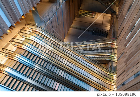 Saint-Denis Pleyel station interior near Paris, France. Modern architecture features wooden walls and crisscrossing escalators in the new Grand Paris Express transport hub 135098190