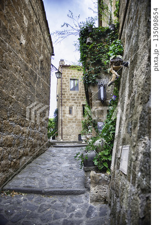 Narrow Stone Alley in Historic Civita di Bagnoregio with Lush 135098654