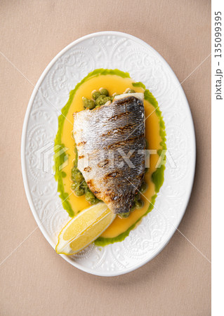 Pan seared sea bass with green pea puree Pan seared sea bass with green pea puree 135099395