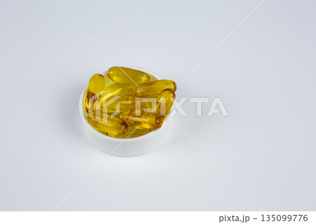 Amber capsules with Omega 3 fish oil containing polyunsaturated fatty acids, including eicosapentaenoic acid, EPA, and docosahexaenoic acid, DHA. Omega-3 fish oil capsules on white background Amber capsules with Omega 3 fish oil containing polyunsaturated fatty acids, including eicosapentaenoic acid, EPA, and docosahexaenoic acid, DHA. Omega-3 fish oil capsules on white background 135099776