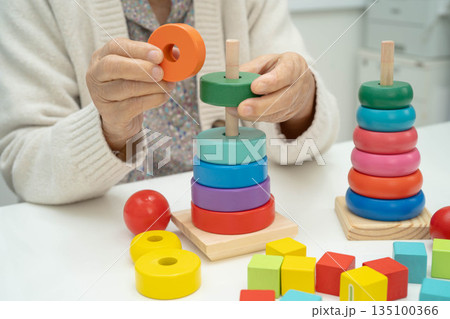 Asian elderly woman playing enhancing skill board game. Asian elderly woman playing enhancing skill board game. 135100366