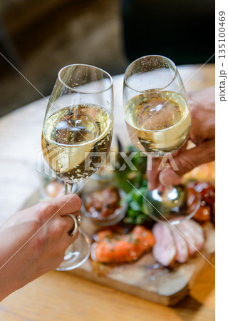 スパークリングワインで乾杯する場面、縦構図 スパークリングワインで乾杯する場面、縦構図 135100469