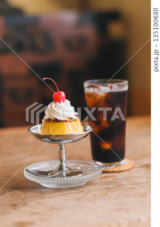 レトロな喫茶店のテーブルに並ぶプリンとアイスコーヒー レトロな喫茶店のテーブルに並ぶプリンとアイスコーヒー 135100680