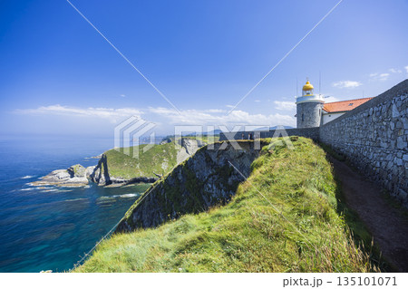 Cudillero lighthouse illuminating rugged Asturias coast in Spain 135101071