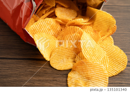 Potato chips, delicious BBQ seasoning spicy for crips, thin slice deep fried snack fast food in open bag. Potato chips, delicious BBQ seasoning spicy for crips, thin slice deep fried snack fast food in open bag. 135101340