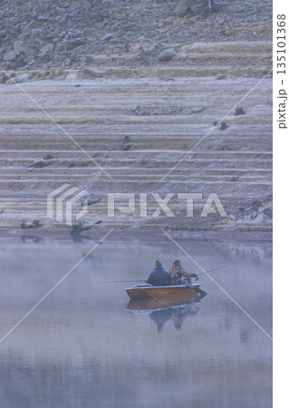 Two men fishing in boat on Zvikov reservoir in winter 135101368