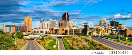 Saint Paul skyline stands in Minnesota, USA. Cityscape view features downtown skyscrapers and highway roads under a blue sky with clouds in the Twin Cities 135101423