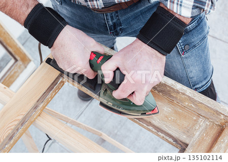 Carpenter at work, restoring an old wooden window. Carpentry. Carpenter at work, restoring an old wooden window. Carpentry. 135102114