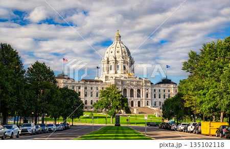 Minnesota State Capitol is located in Saint Paul, USA. Historic Beaux-Arts architecture features the white marble dome and golden Quadriga statue under a blue sky with clouds 135102118