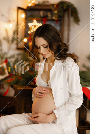 Pregnant woman enjoying Christmas holiday preparing for motherhood Pregnant woman enjoying Christmas holiday preparing for motherhood 135102583