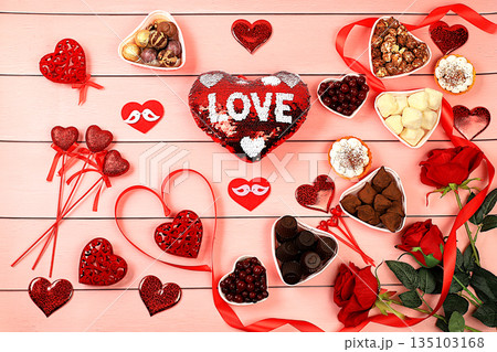 Food for Valentine's Day or Women's Day, Gourmet heart shaped chocolate candies, sugar cranberry, meringue and rose flowers, greeting card, advertising banner or store invitation. Food for Valentine's Day or Women's Day, Gourmet heart shaped chocolate candies, sugar cranberry, meringue and rose flowers, greeting card, advertising banner or store invitation. 135103168