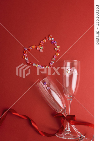 Champagne Flute Glasses with Colorful Heart made from Confetti on Red Background. Valentines Day Celebration Champagne Flute Glasses with Colorful Heart made from Confetti on Red Background. Valentines Day Celebration 135103363