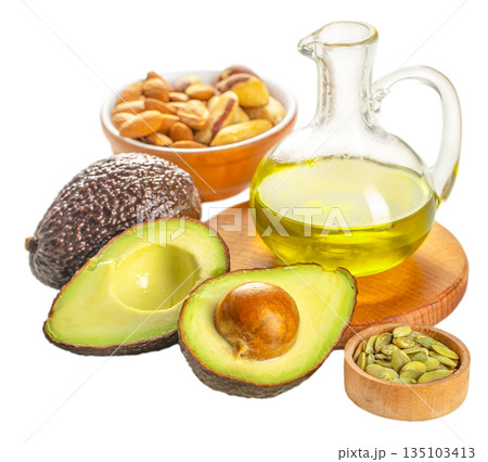 Avocado oil with fresh avocados and nuts as omega fatty acids healthy food concept isolated on white Avocado oil with fresh avocados and nuts as omega fatty acids healthy food concept isolated on white 135103413