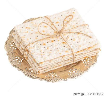 Traditional Jewish matzah bread stacked on decorative plate isolated on white background Traditional Jewish matzah bread stacked on decorative plate isolated on white background 135103417