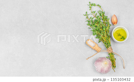 Fresh thyme herbs with garlic, olive oil and sea salt on light stone background, top view flat lay with copy space for healthy cooking and culinary branding concept Fresh thyme herbs with garlic, olive oil and sea salt on light stone background, top view flat lay with copy space for healthy cooking and culinary branding concept 135103432