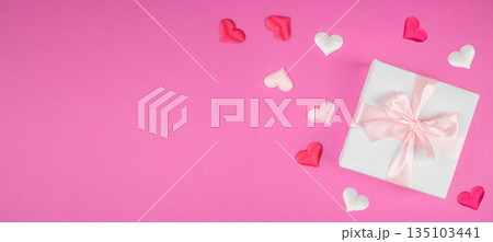 White gift box with pink ribbon and hearts on pink background with copy space, top view White gift box with pink ribbon and hearts on pink background with copy space, top view 135103441