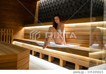 Beautiful young woman in white robe feeling relaxed in a spa center Beautiful young woman in white robe feeling relaxed in a spa center 135105021