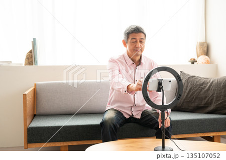 動画配信するシニア男性 135107052