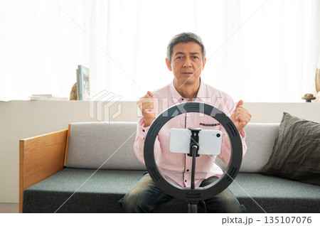 動画配信するシニア男性 135107076