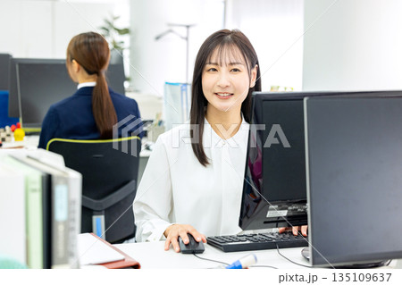 デスクワークをするビジネスウーマン デスクワークをするビジネスウーマン 135109637