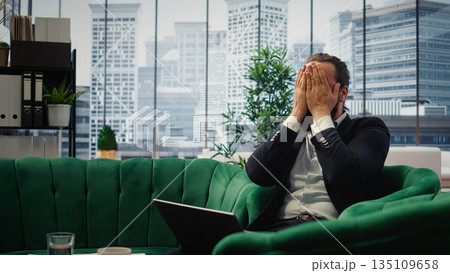 Overburdened director dealing with workload and financial instability, struggling to keep his business economy on the line. Unsuccessful anxious man feeling hopeless due to problems. Camera A. 135109658