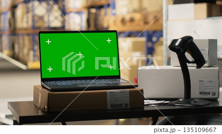 Order fulfillment modern desk with chroma key on a laptop in distribution hub, retail import export activity. Industrial space for barcode tracking and inventory control systems. E-commerce. 135109667