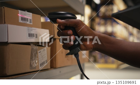 Close up of logistics staff scanning airway bill tags for inventory registration, updating records in import export system on tablet. Retail e-commerce operations in industrial depot. Camera A. Close up of logistics staff scanning airway bill tags for inventory registration, updating records in import export system on tablet. Retail e-commerce operations in industrial depot. Camera A. 135109691