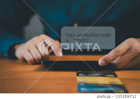Online security and authentication concept showing a person receiving verification code on smartphone with credit cards, symbolizing two-factor authentication and secure digital payment. Online security and authentication concept showing a person receiving verification code on smartphone with credit cards, symbolizing two-factor authentication and secure digital payment. 135109712