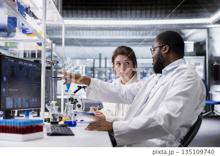 Diagnostic laboratory manager and trainee working together to process DNA patient data for clinical research. Lab team leader and intern use PC program to do genetic analysis diagnostics Diagnostic laboratory manager and trainee working together to process DNA patient data for clinical research. Lab team leader and intern use PC program to do genetic analysis diagnostics 135109740
