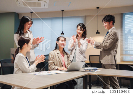 オフィスメンバーから拍手喝采される女性社員 135110468