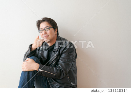 指を差す革ジャンの50代男性 135110514