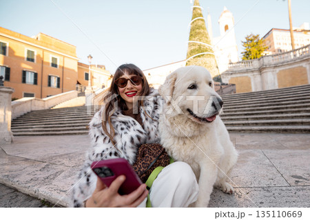 Woman taking a selfie with dog near the Spanish Steps in Rome during holiday season 135110669