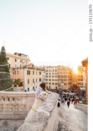 Woman with dog enjoying festive sunset view near the Spanish Steps in Rome 135110670