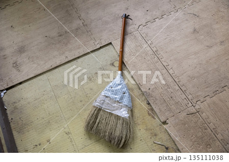 古くて汚れた床に置かれた座敷箒 135111038