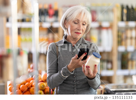 Elderly woman scanning qr code for mayonnaise 135111133