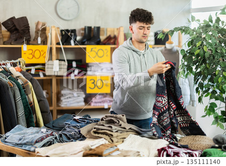 Regular customer guy chooses color and style of sweater 135111140