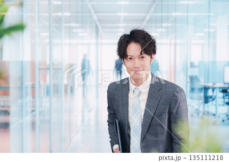 ガラス張りのオフィスの入口でお辞儀をする男性 ガラス張りのオフィスの入口でお辞儀をする男性 135111218