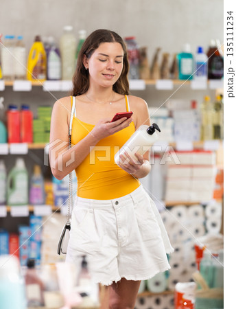 Checking expiration date of spray glass cleaner for windows - female shopper scans QR code on label of spray glass cleaner for windows using smartphone Checking expiration date of spray glass cleaner for windows - female shopper scans QR code on label of spray glass cleaner for windows using smartphone 135111234