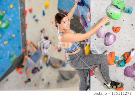 Young woman practicing rock climbing on climbing wall Young woman practicing rock climbing on climbing wall 135111278