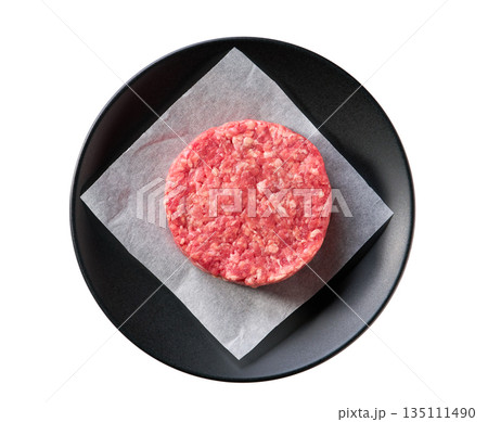 black plate with raw ground beef patty for hamburgers isolated on white background, top view. 135111490