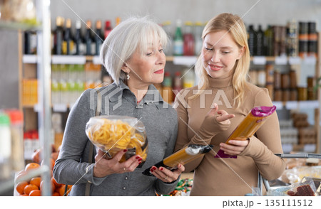 Family shopping at supermarket - choosing spaghetti and pasta in grocery section 135111512