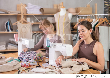 Two female tailors working in the workshop Two female tailors working in the workshop 135111575